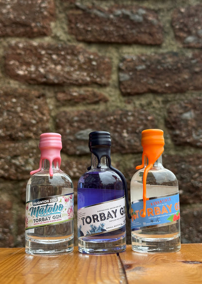 miniature gin bottles on bar in front of cockington brick wall